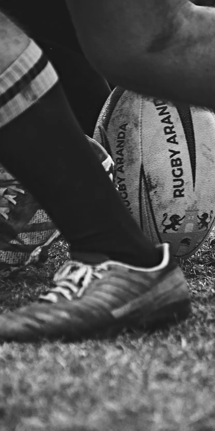 Rugby players’ boots and legs in a scrum on the grass