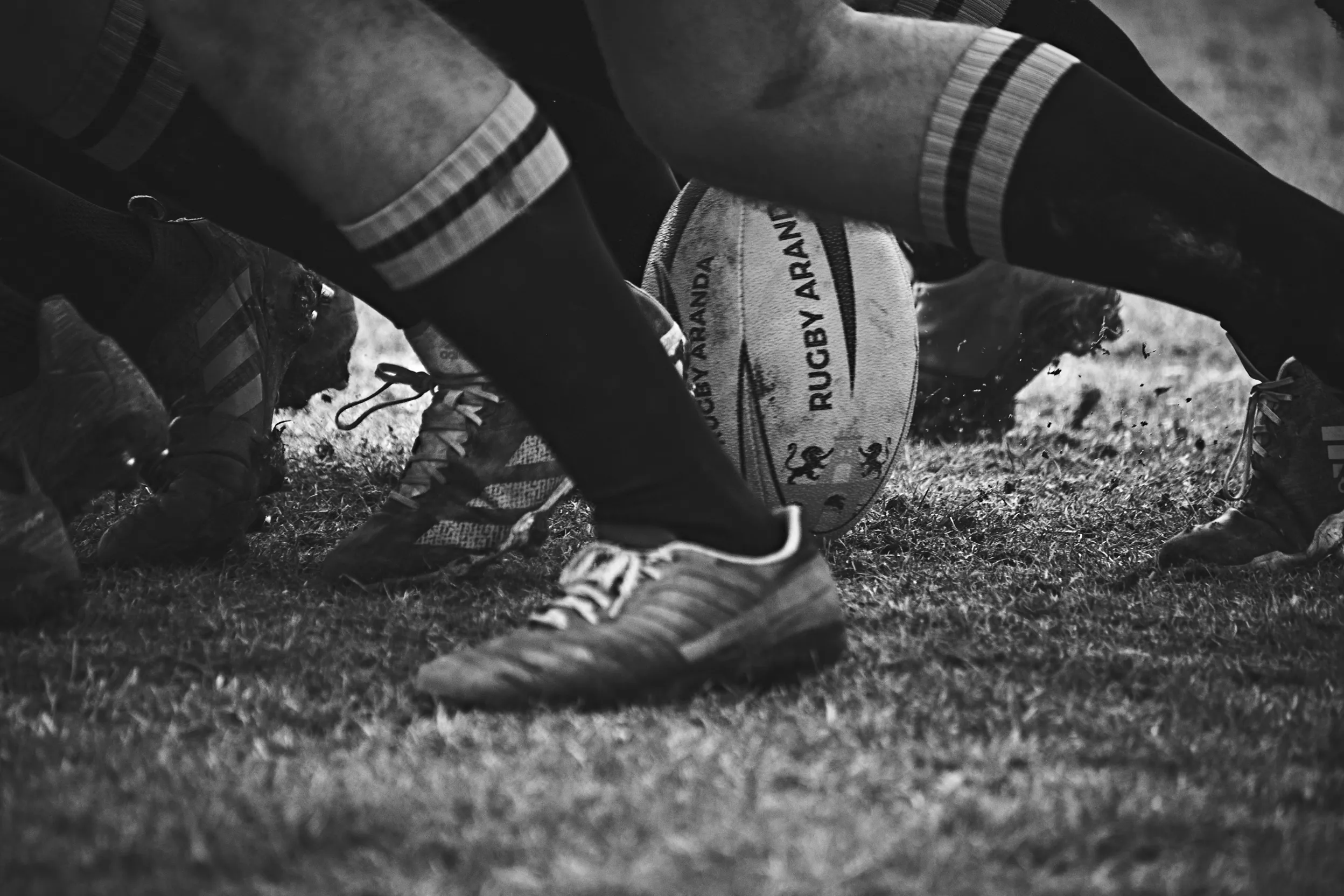Rugby players’ boots and legs in a scrum on the grass