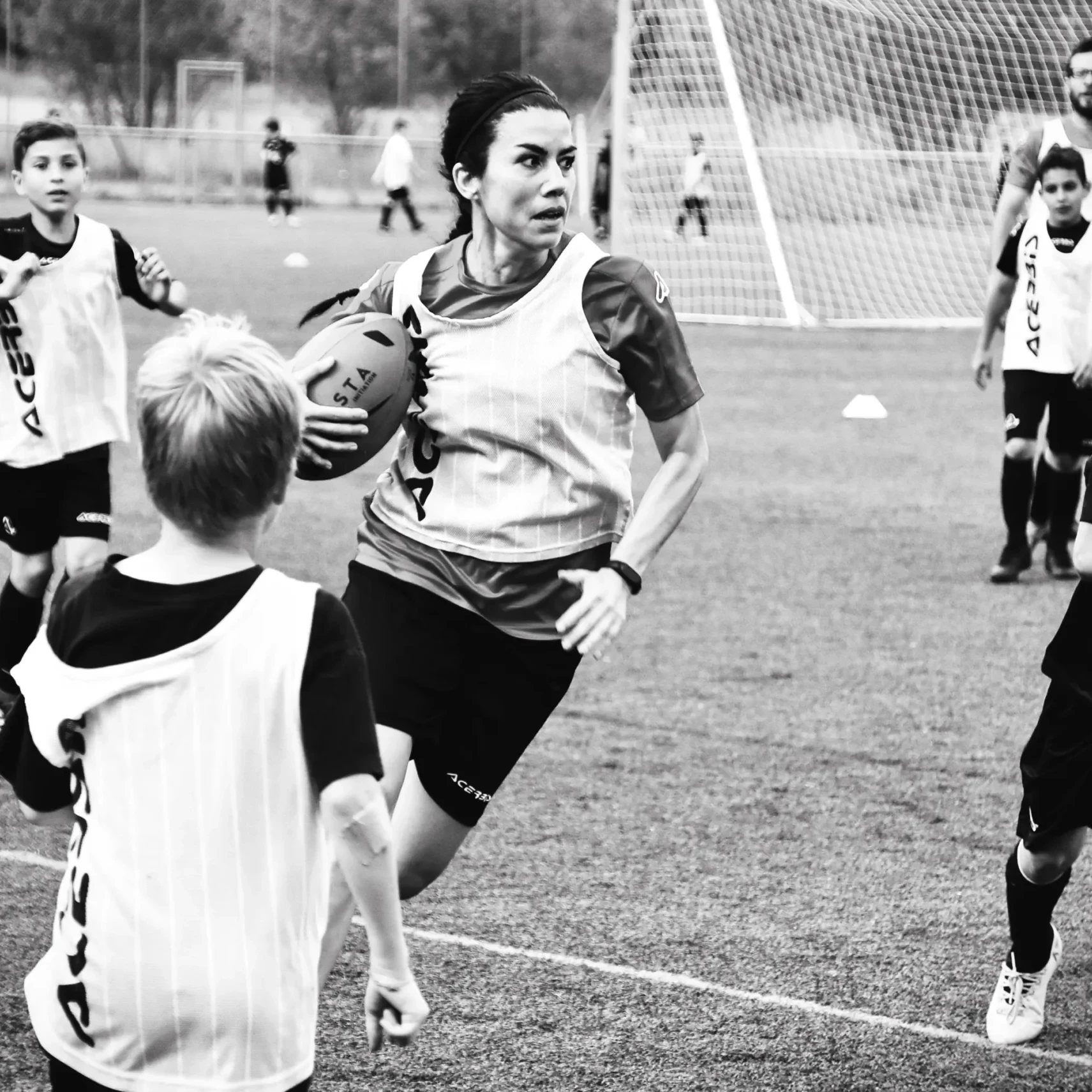 Children playing rugby on a grass field