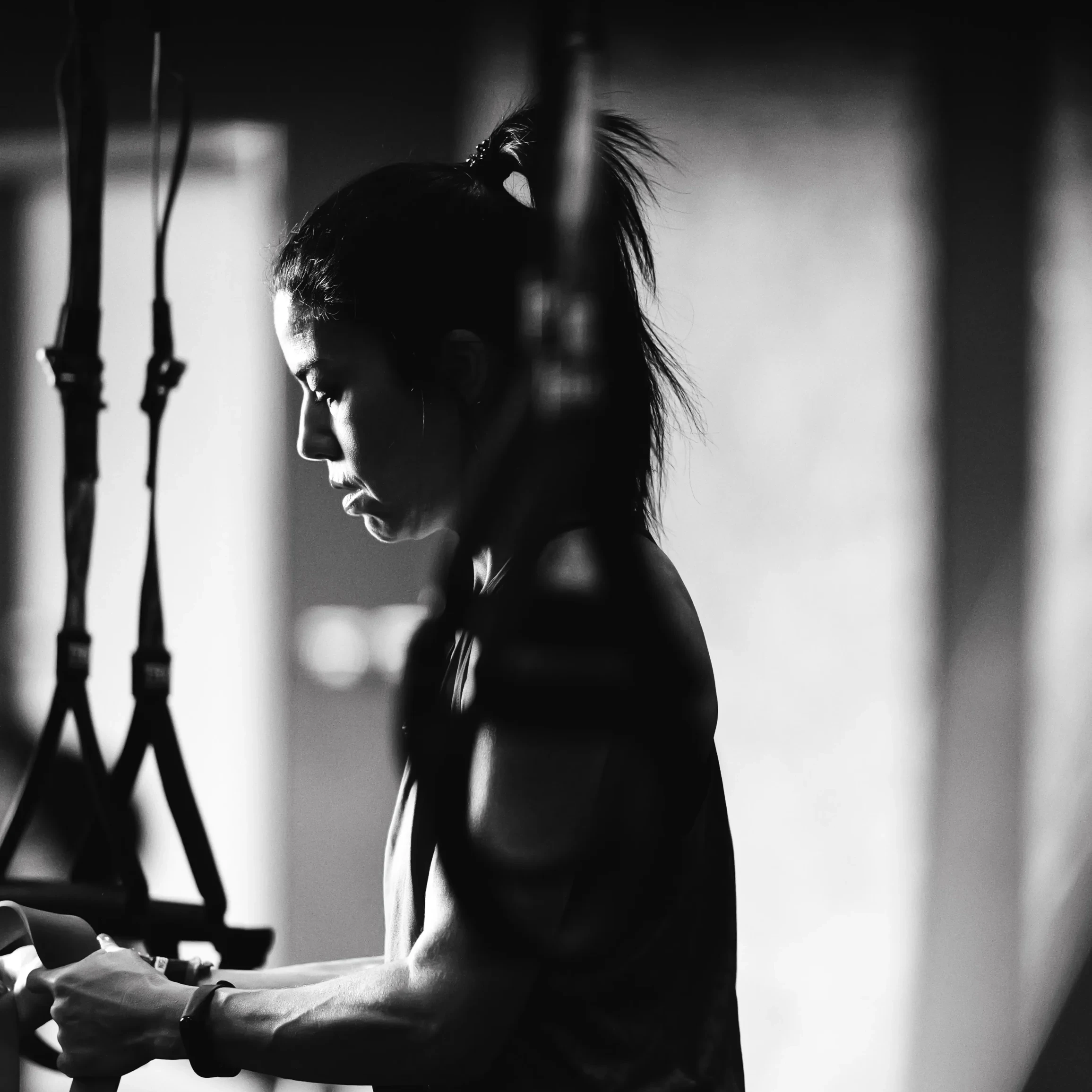 Woman training with suspension straps in the gym