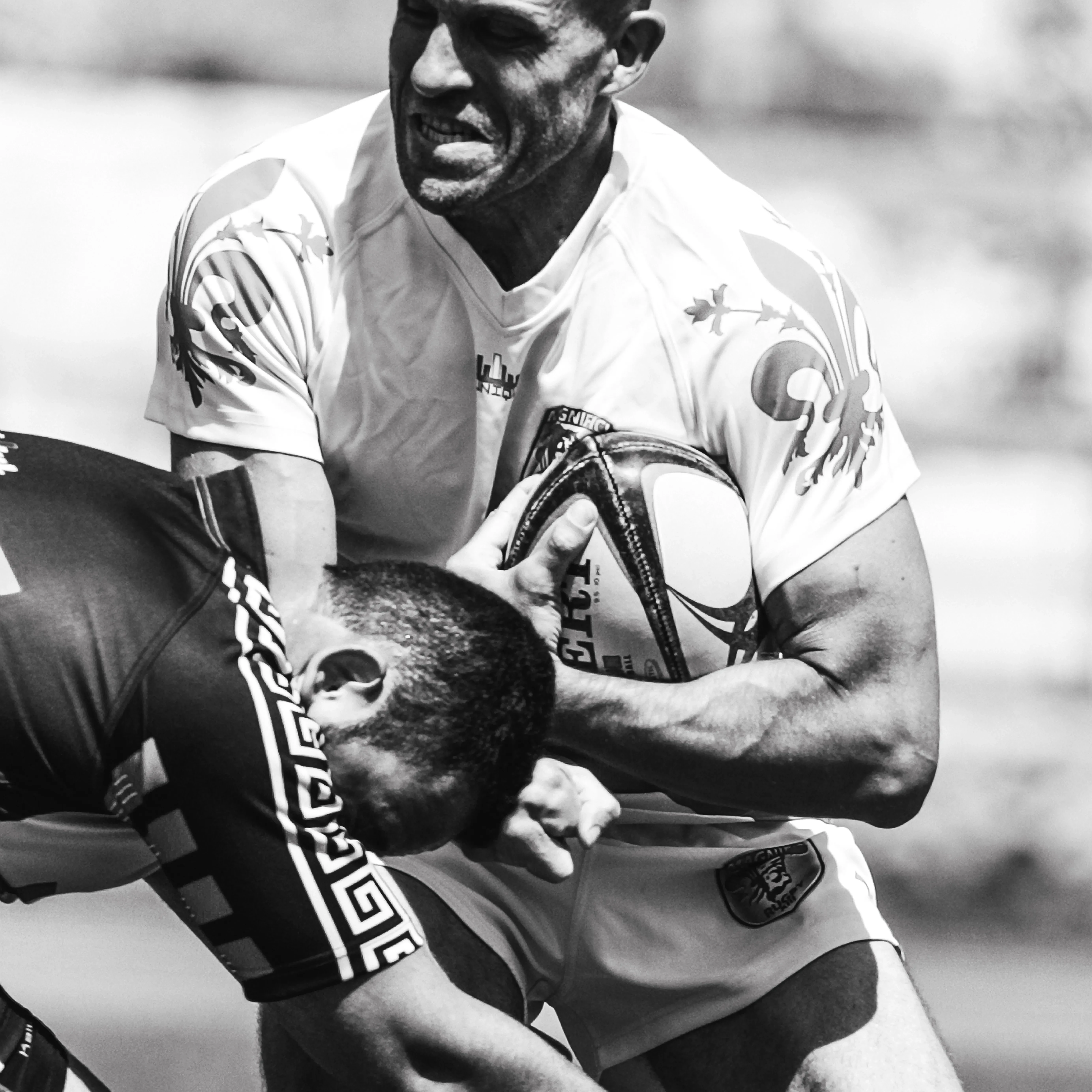 Two rugby players in close contact during a tackle